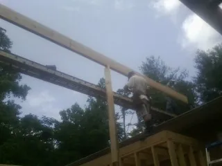 Carpenter setting a ridge beam over a new addition frame — Ice Dam Removal by Roofing Brothers in Escondido